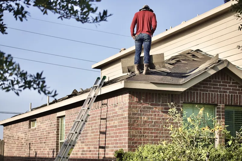 Professional roofer working on a residential roof in Muhlenberg Park